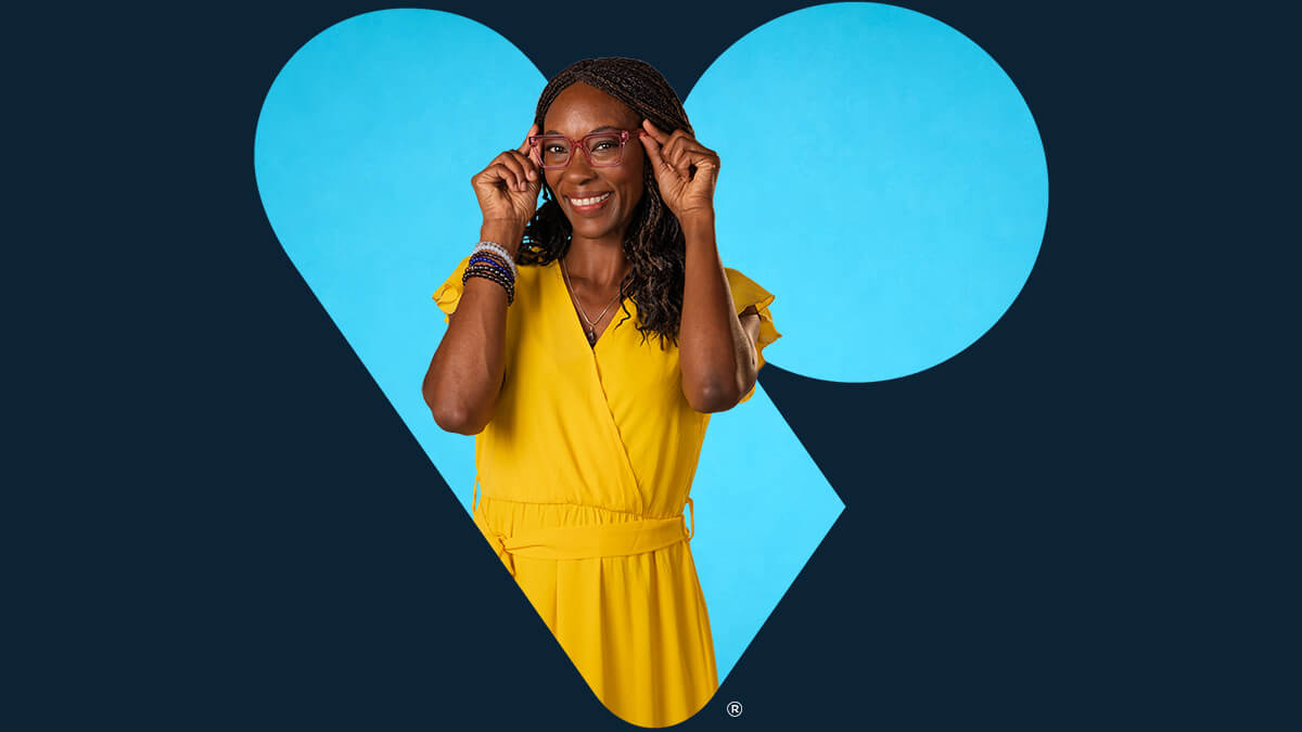 Woman adjusting her glasses inside a light blue VSP heart on a deep blue background.